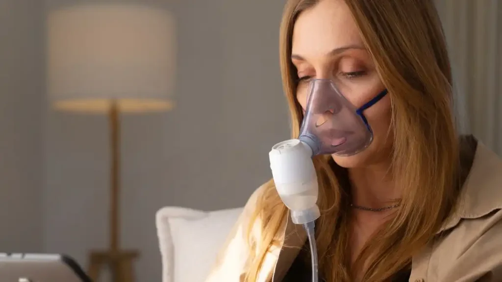 Inalação com Clenil A e soro fisiológico: Como fazer corretamente 3 Pessoa realizando inalação com Clenil A e soro fisiológico em nebulizador pneumático em casa